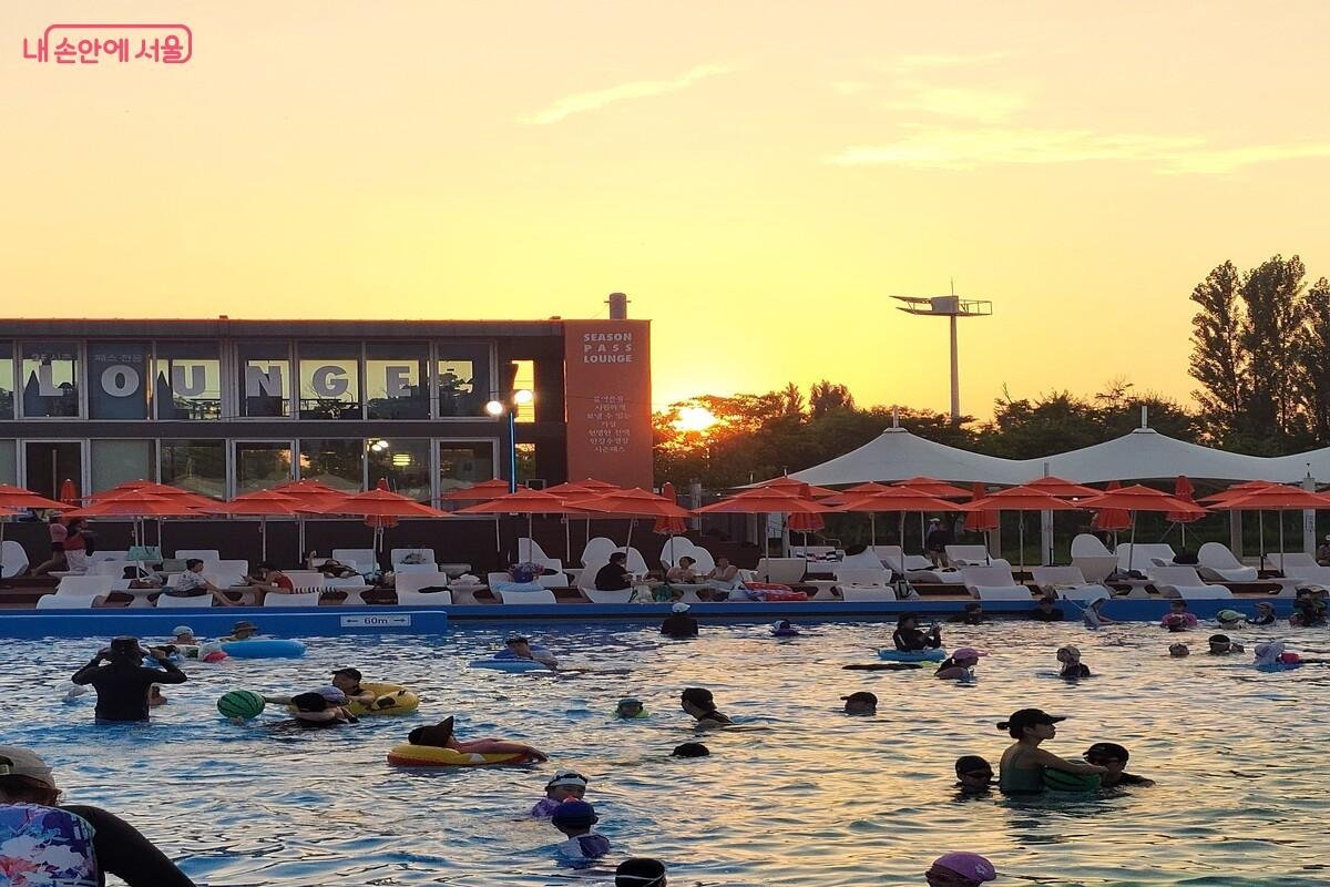 Han River outdoor swimming pool in Seoul at sunset with orange parasols