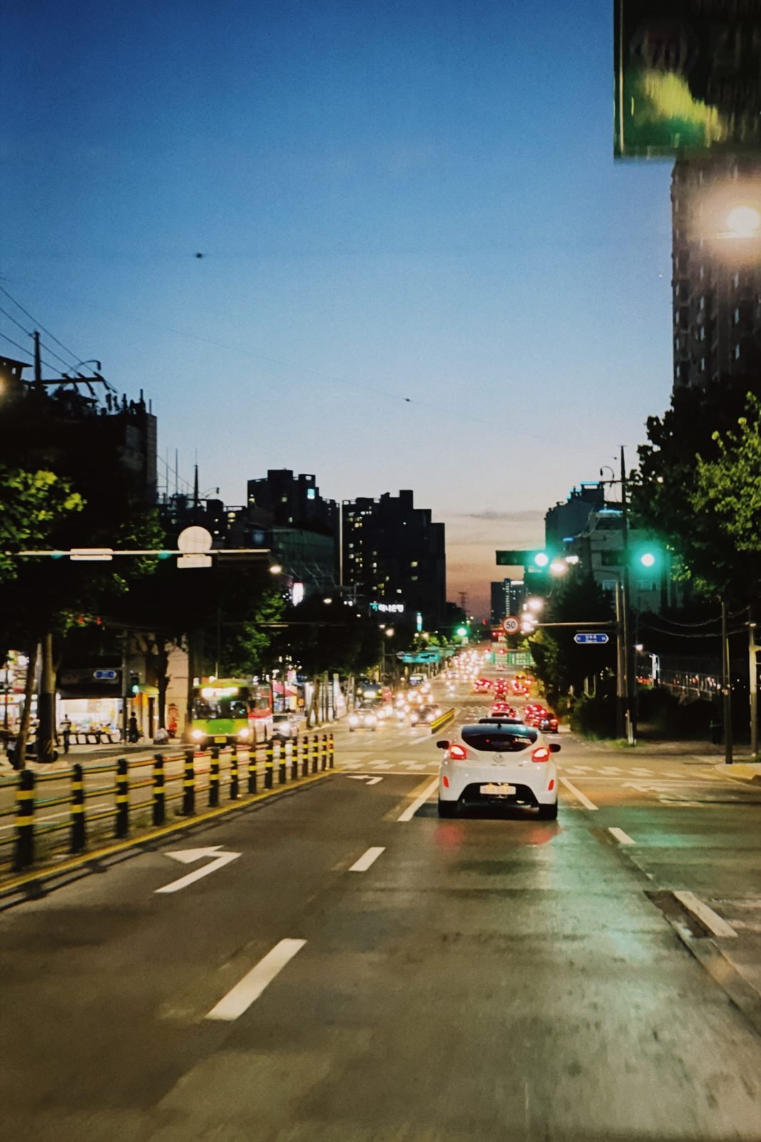 Summer dusk over a Seoul street with a red sunset sky