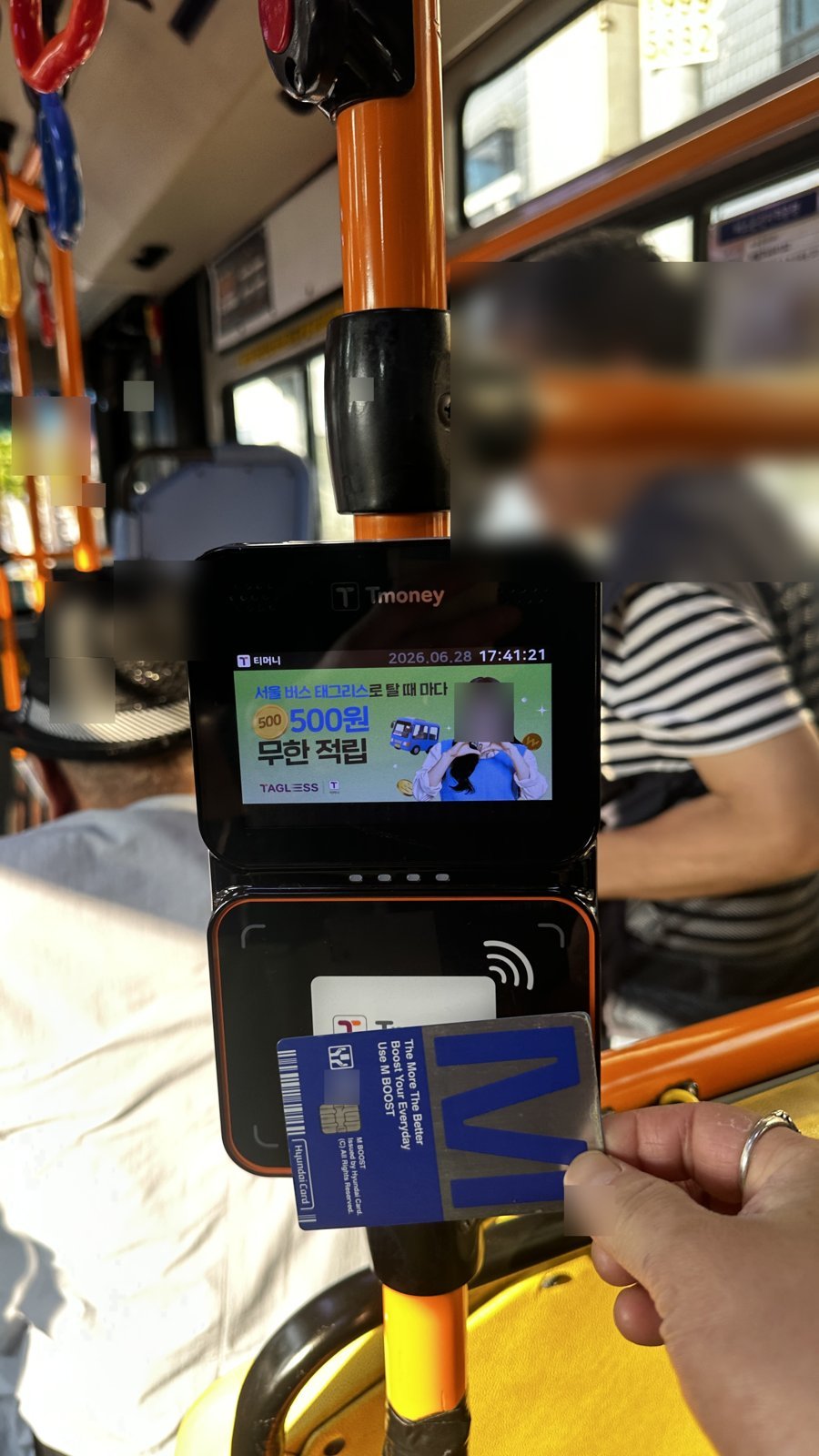 Tapping a transit card on a Seoul city bus reader to tap off when exiting